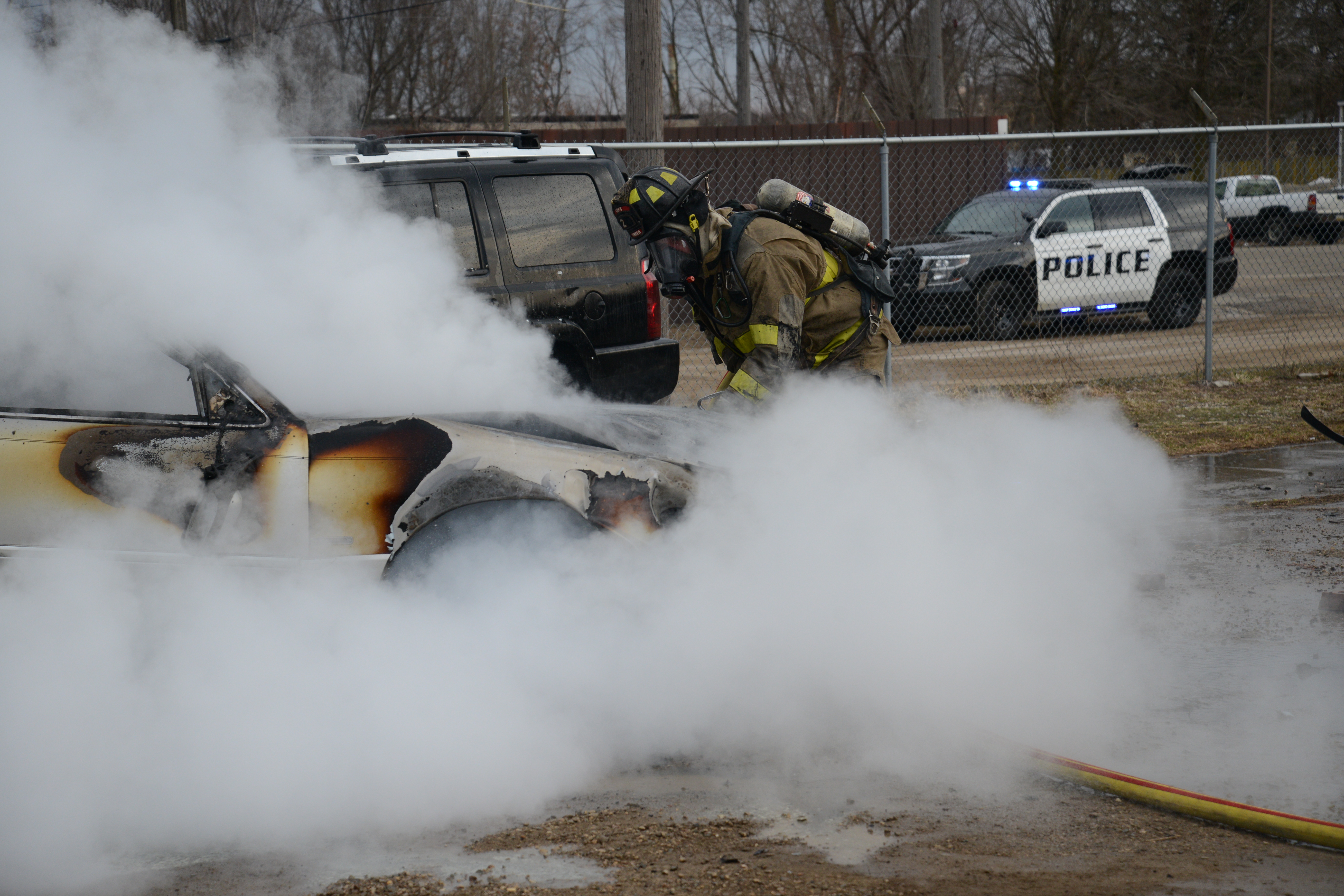 Photo of a Public Safety Officer extinguishing a vehicle fire.