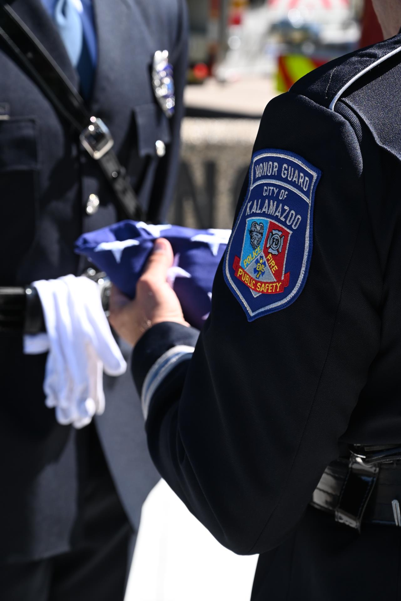 Photo of a member of the KDPS Honor Guard presentign a folded flag.